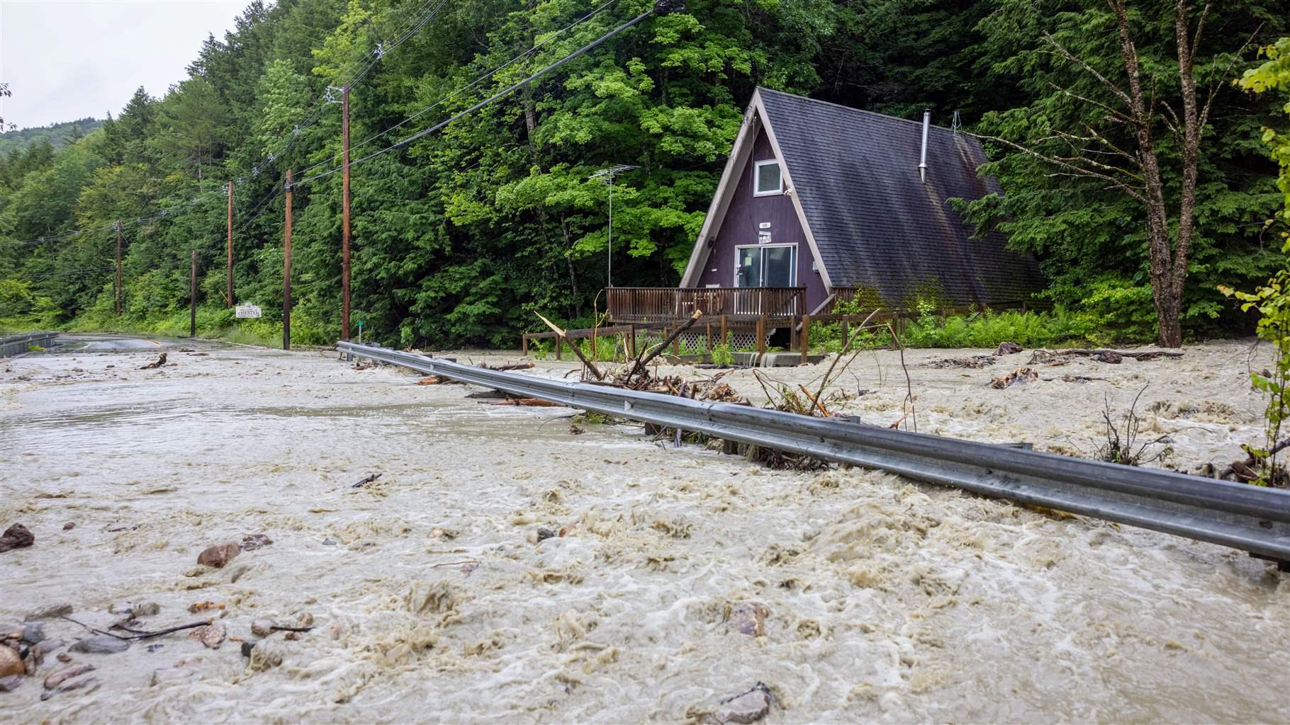 Floodwaters surrounded the house and covered a nearby highway, littered with fallen branches. 