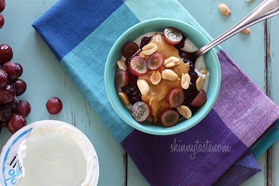 Peanut butter, grape jam, hazelnuts, and fresh red grapes on top of a bowl of yogurt...who needs bread!